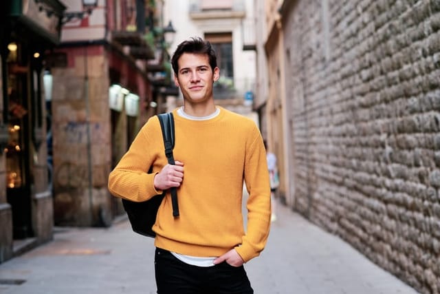 millennial guy with backpack in city