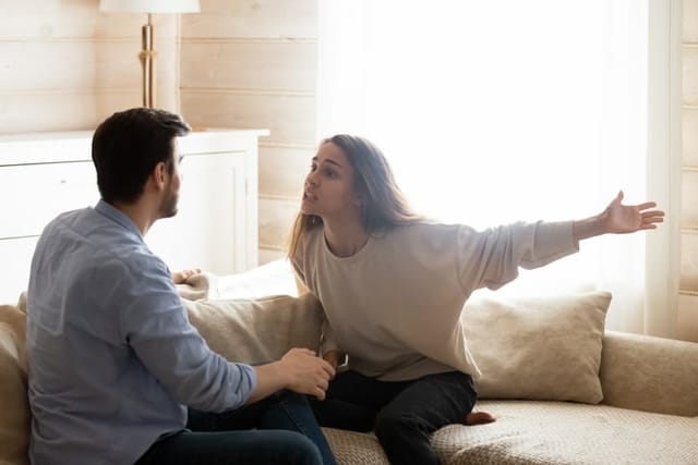 young couple fighting at home on couch