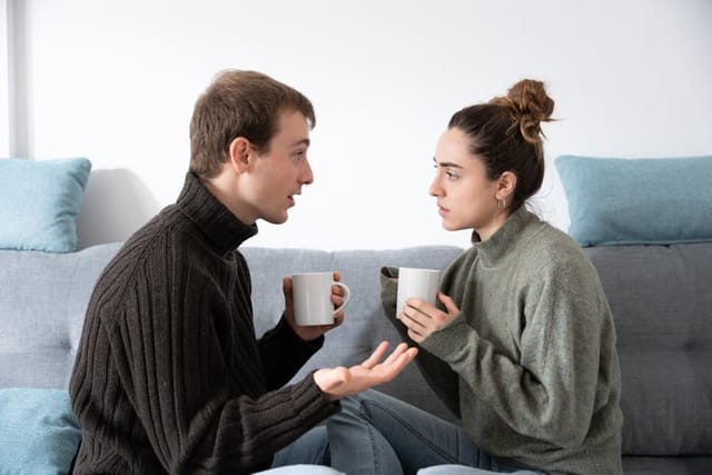 Young couple having conversation on couch