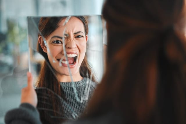 woman looking in the mirror getting angry