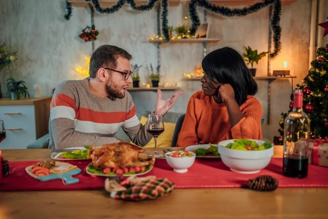 couple fighting at christmas dinner table