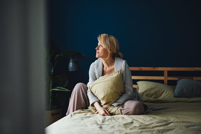 Smiling Woman Relaxing In Bed In The Morning