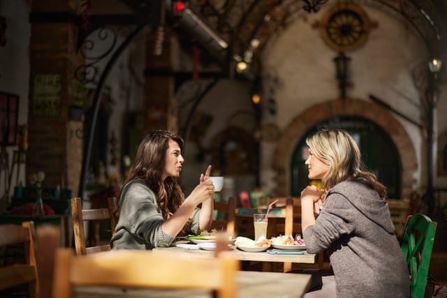 Young happy women enjoying in conversation during a meal at the restaurant.