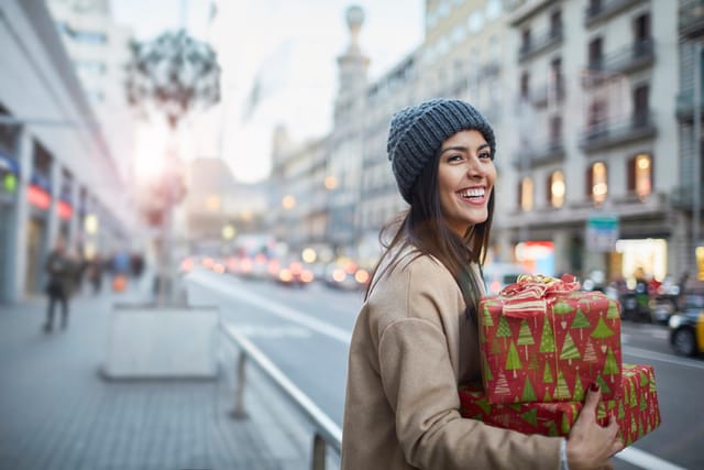 woman carrying a christmas present in city