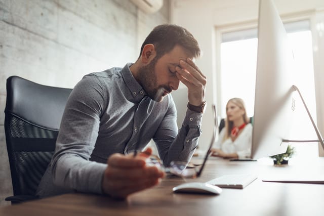 stressed man at work desk