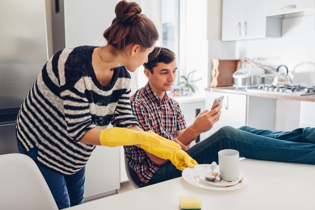 woman cleaning up after lazy husband