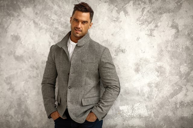 Portrait of handsome smiling man in gray stylish jacket with copy space for your text