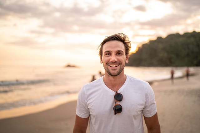 smiling man white t-shirt on beach