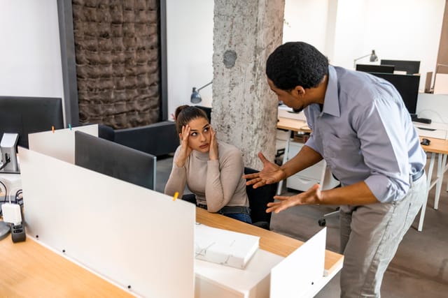 boss talking to frustrated female colleague