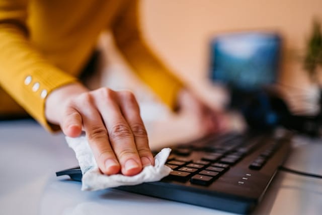 Woman cleaning her keyboard.