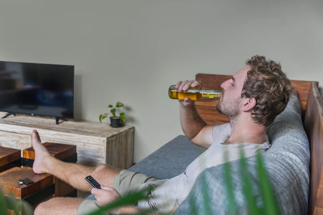 lazy man drinking on couch