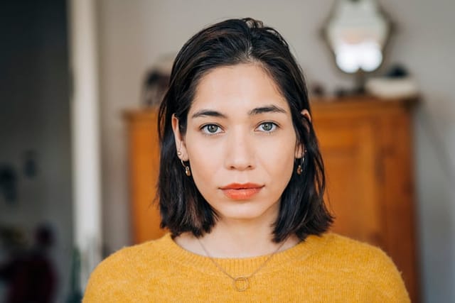 Close-up portrait of a confident woman at home.