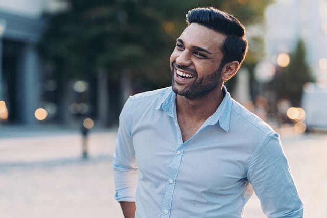 smiling businessman in blue shirt outside