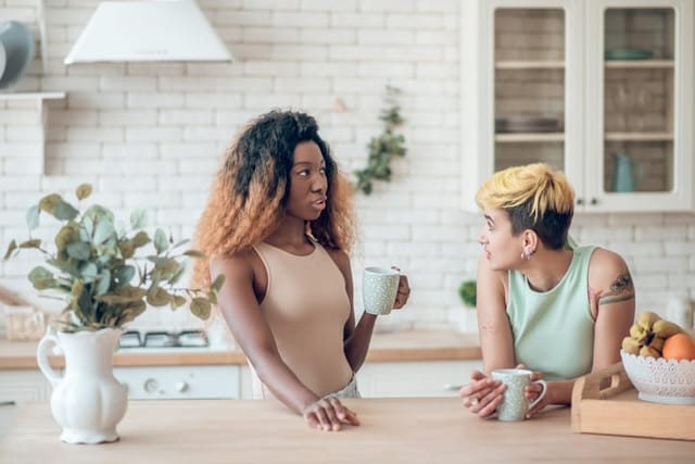two friends chatting in a kitchen