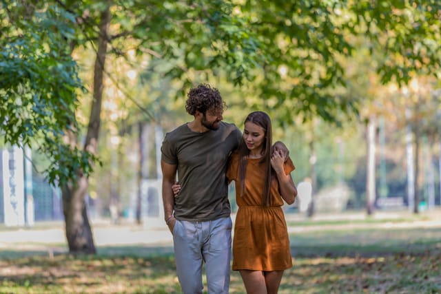 millennial couple walking in park