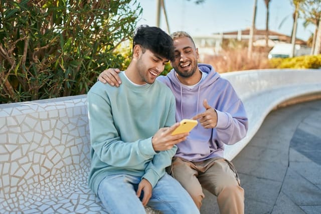 gay couple smiling looking at phone