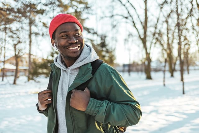 Young African man Walking in winter forest