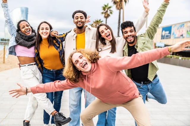 Multiracial group of people with hands up smiling at camera outside - Happy guys and girls having fun together walking on city street - Happy friendship, community and human resources concept