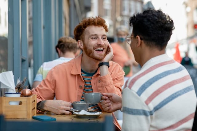 two male friends having coffee outside