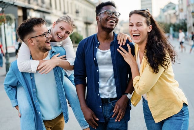 Shot of diverse group of cheerful young people talking and laughing while walking through the city.