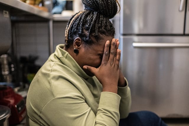 upset woman with her head in her hands