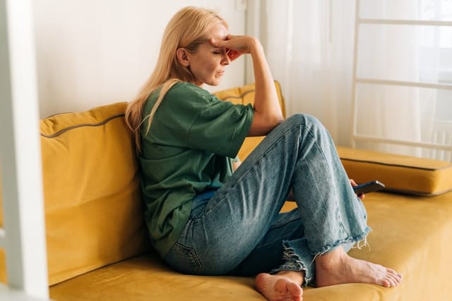 sad woman blonde hair on couch