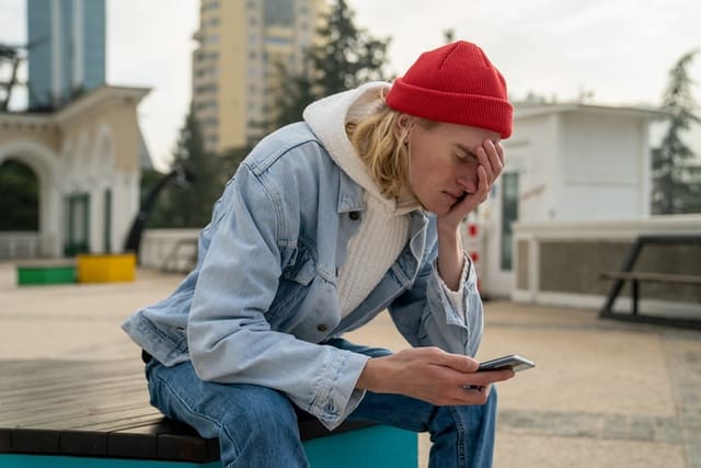 guy covering his face with phone