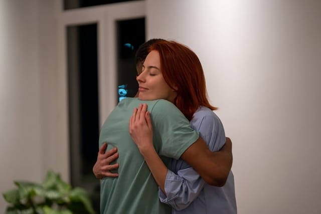 Young multiracial couple woman and man hugging while making up at home, loving supportive wife embracing husband gently, showing love and support. Understanding in relationships, tactility and hugs
