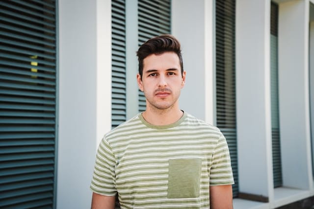 man with striped shirt looking serious