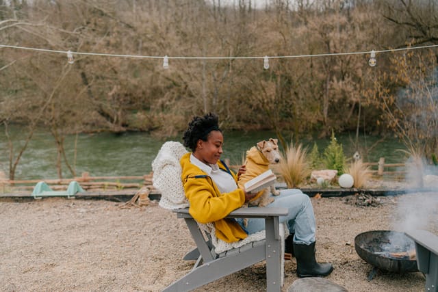 woman reading by water outside