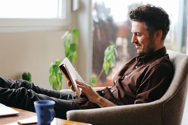 man sitting and reading book