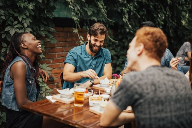 Happy multi-ethnic group of people laughing at the restaurant