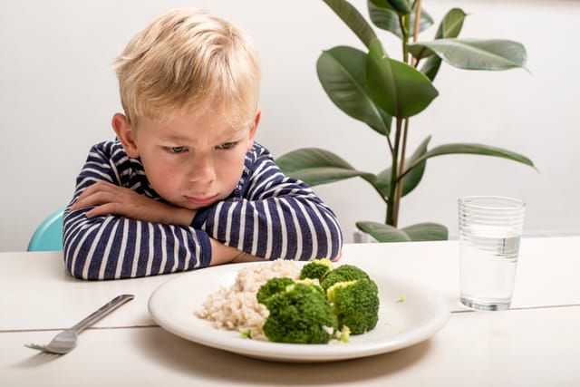 sad kid won't eat vegetables