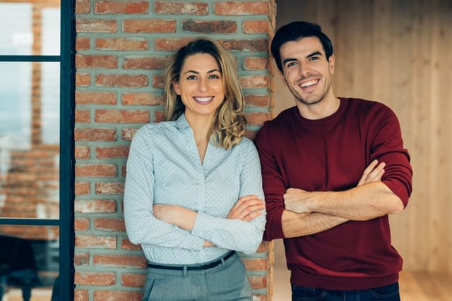 man and woman smiling in office