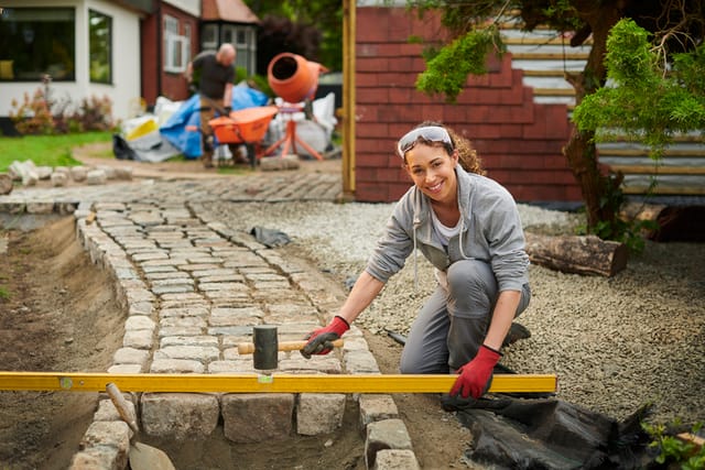 woman laying cobbled path