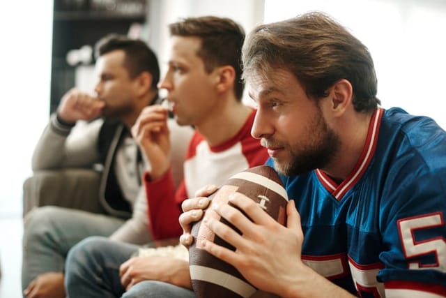 men watching american football on couch