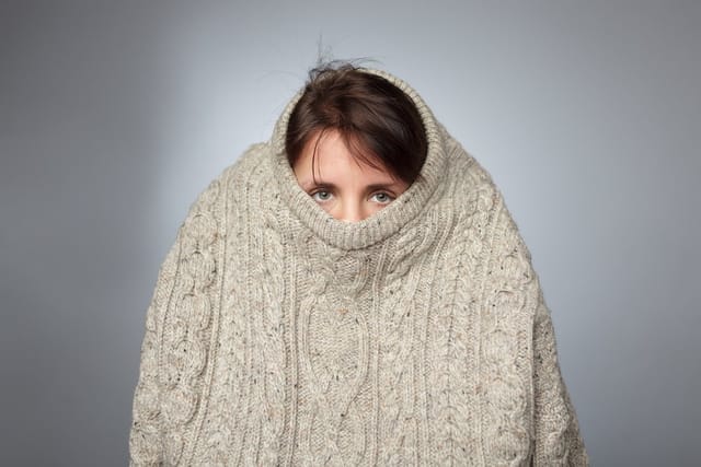 introverted woman hiding in sweater