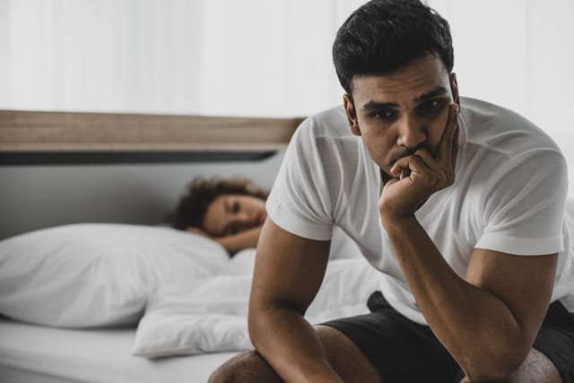 Couple in an argument in bed.
