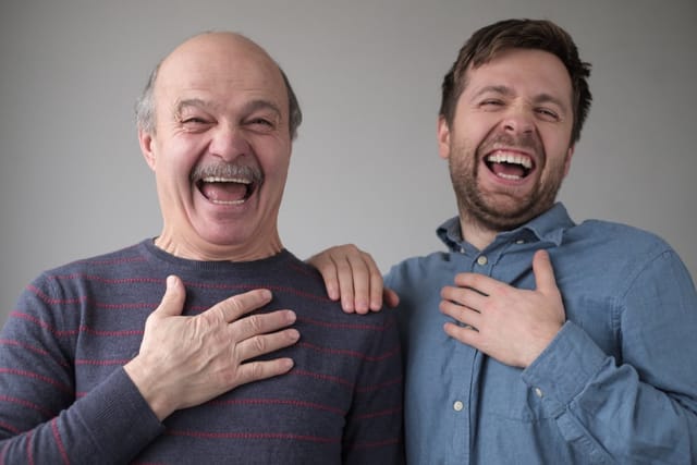 Two men laughing hard at a joke.