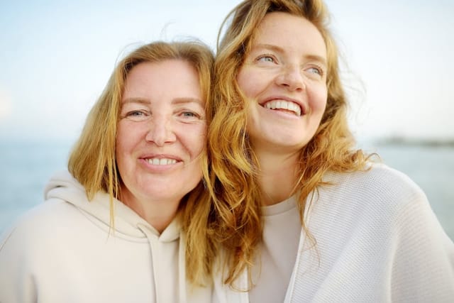 Mother and her adult daughter embrace.
