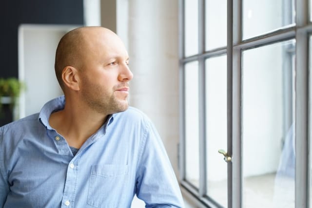 Man watching the world go by from his window.