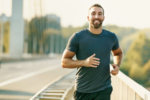 Man running and smiling outside.
