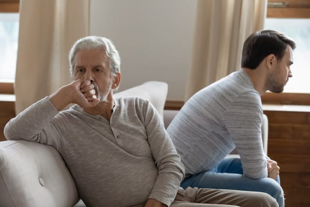 Unhappy father and son having a serious conversation at home.