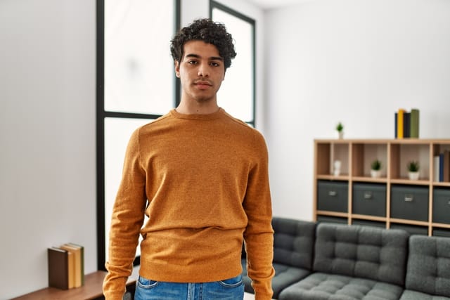 Young man wearing an uncomfortable sweater.