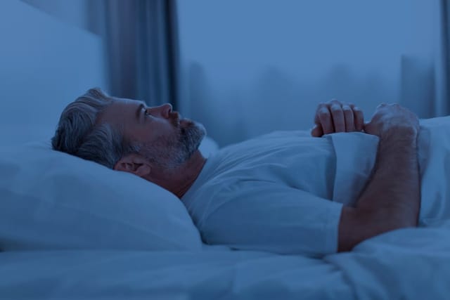 Insomnia, middle aged man trying to sleep.