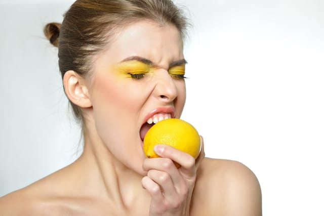 Woman with a lemon in her mouth.