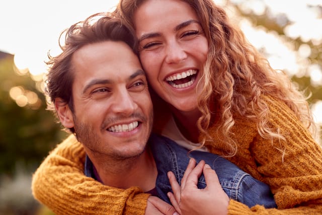 happy couple smiling embracing outdoors
