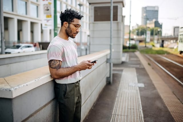 hipster guy texting in city