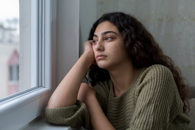 sad woman looking out window