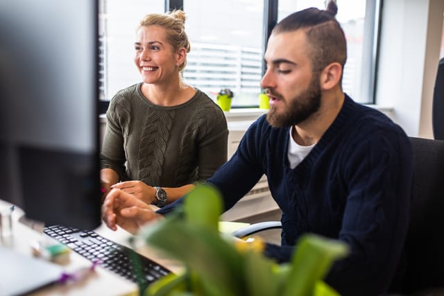 male and female colleagues at computer